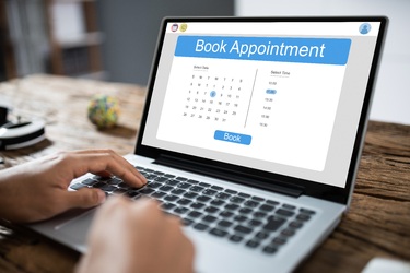 A person booking an appointment online using a laptop